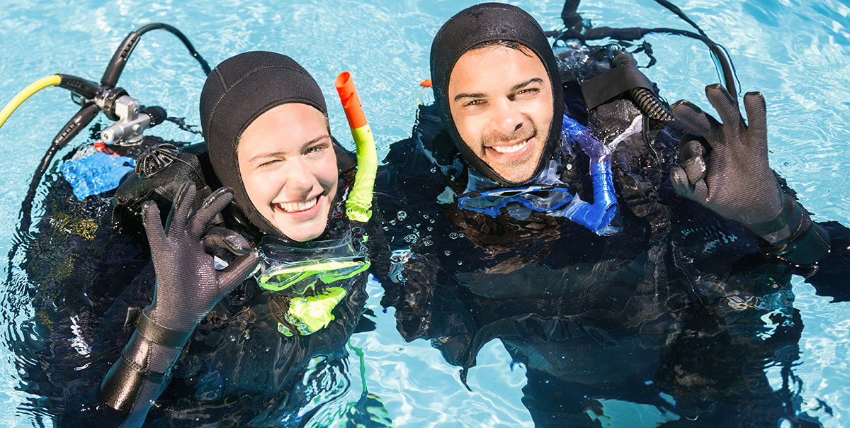 A woman and a man with scuba gear in a pool.