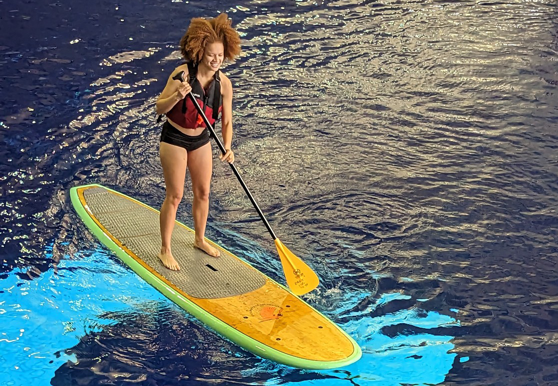 A gal paddle boarding in the GT competition pool on Rec Day 2023.