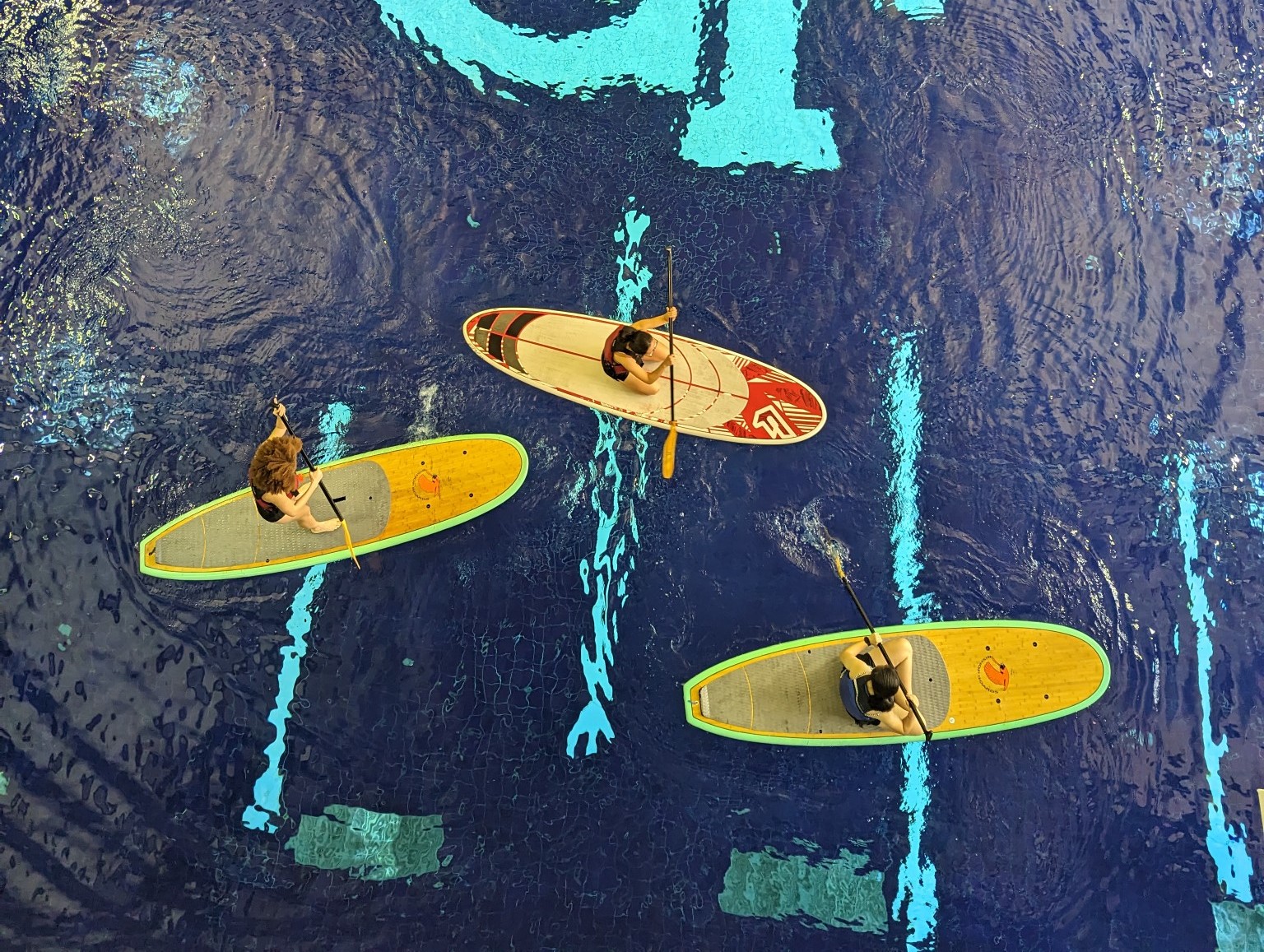 Participants paddleboarding in the competition pool